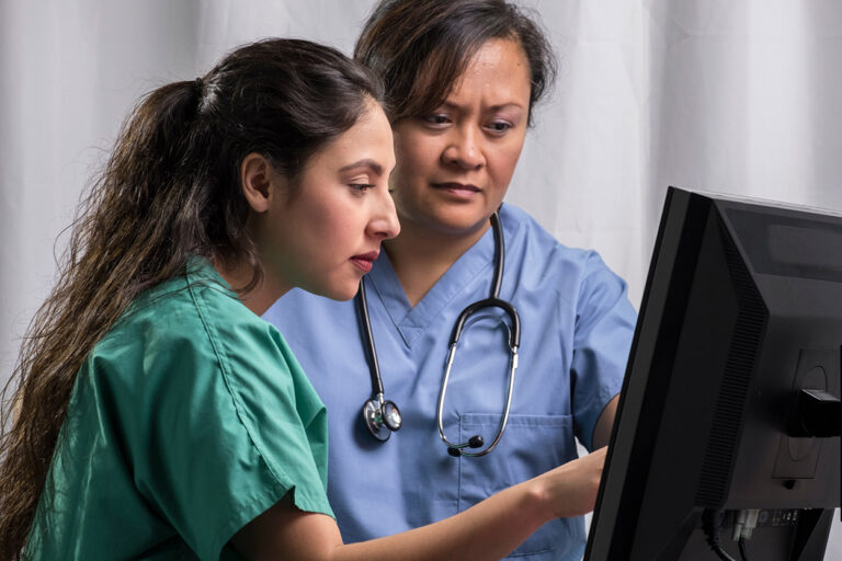 Medical team reading computer screen together